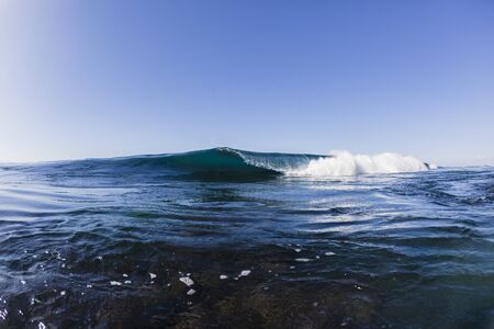 Ocean wave reef shallow  crashing blue water swimming closeup.
