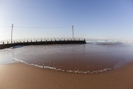 Tidal Pool ocean waves over beach sands  landscapeの写真素材