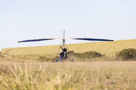 Flying microlight  plane pilot landing on rural countryside grass airstrip