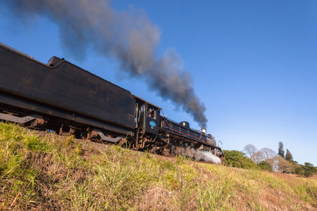 Steam train with passenger coaches and tourists departs Kloof station and powers its way towards...