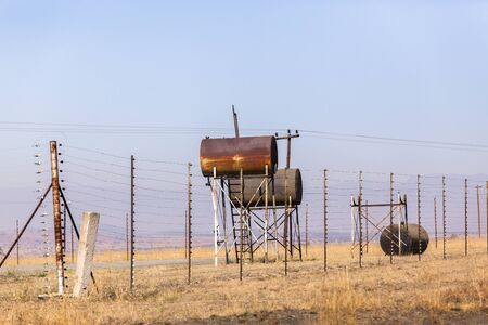 Fuel tanks at abandoned deserted rural gas station in dry landscape