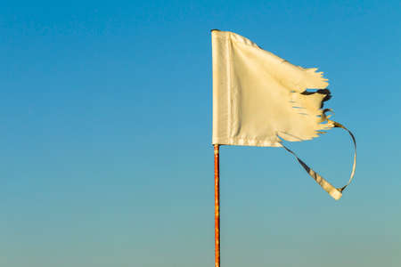 Golf hole flag pin shredded high winds countrysideの写真素材