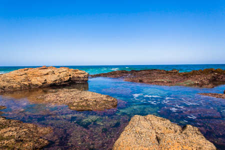 Ocean wave crashing rocky coastline exploding white water powerの写真素材