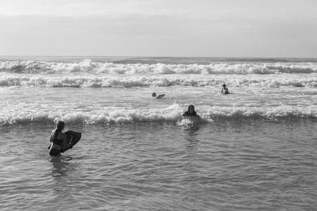 Teenagers girls boy swimming surfing morning ocean waves