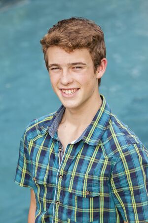 Teen boy standing casual pool vertical photo
