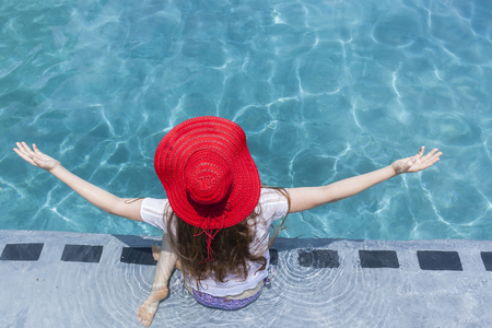 Teenager girl red hat summer swimming pool recreationの写真素材