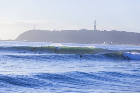 Wave  ocean wall crashing with surfers paddling.の写真素材