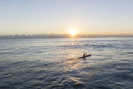 Paddler surf ski canoe ocean waters sunrise trainingの写真素材