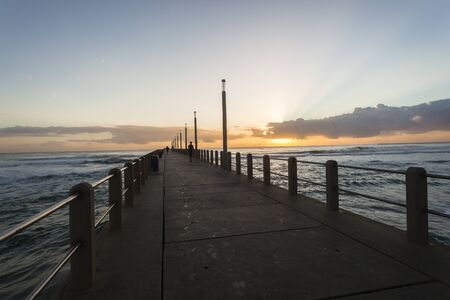 Beach pier jetty ocean waves sunrise sunset landscapeの写真素材