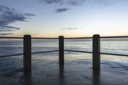 Pier railing platform ocean waters blue sky morning landscapeの写真素材