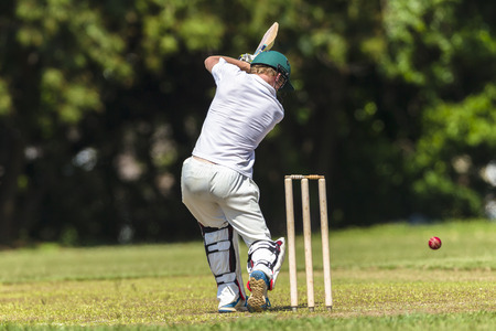 Cricket game closeup player batting ball stroke strike action high school teams.