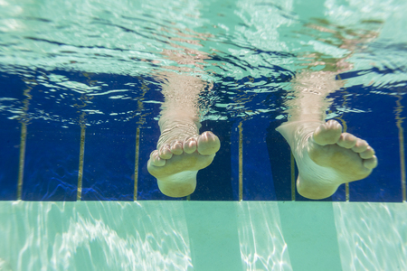 Girls Feet underwater view swimming pool summers dayの写真素材