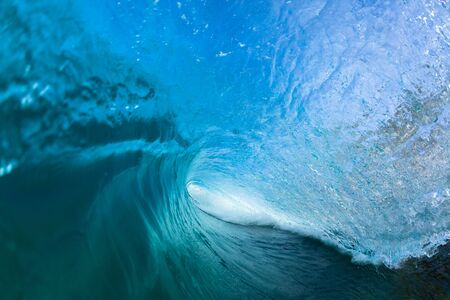 Ocean wave swimming inside hollow crashing surfing tube ride perspective.