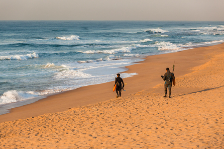 Divers spear fishing guns goggles line buoy beach entry swim into oceanの写真素材