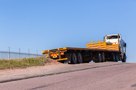 Truck vehicle with yellow haulage trailers awaiting cargo to transport.