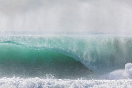 Ocean waves crashing water power towards beach from weather storms.の写真素材