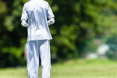 Cricket game teenagers schools player fielder closeup action photo.