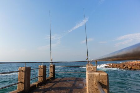 Pier jetty ocean rocky coastline for public  fishing  blue waters.
