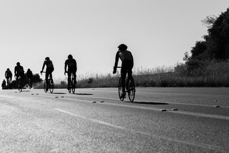 Cyclists Cycling up hill silhouetted road race vintage black white photo.のeditorial素材