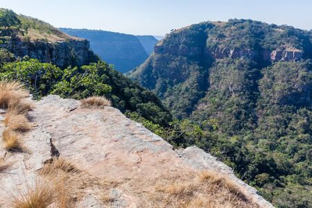Kloof gorge overlooking rocky cliff ledge towards valley hills countryside hiking climbing landscape.の写真素材