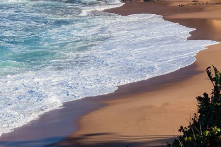 Beach ocean wave white waters wash up shoreline.の写真素材