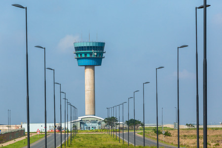 Airport Air traffic control tower for planes in countryside landscape.