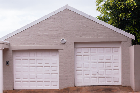 Double garage doors white road entrance for vehicles.