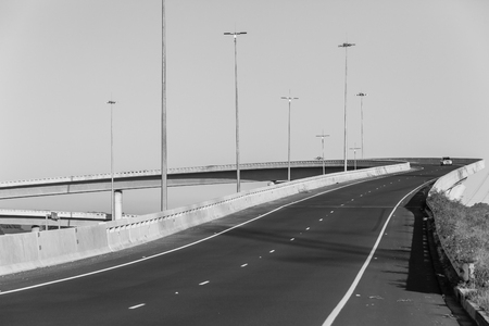 Road highway overhead flyover overpass with vehicle on ramp entry exit structures in black and white.の写真素材