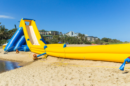 Beach ocean public amusement  thrill rides down high water slide inflated structure during summer holidays.の写真素材