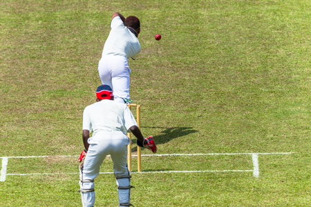 Cricket game action closeup unidentified abstract bowler batsman wicketkeeper.