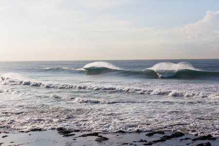 Ocean waves breaking crashing hollow water power spray on coastline reefs landscape.の写真素材