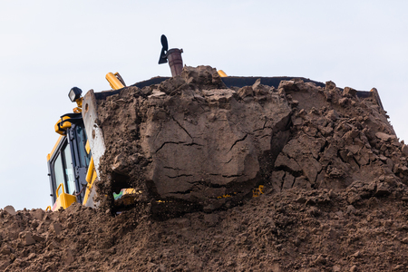 Earthworks construction heavy dozer industrial machine metal scoop bucket pushing sand closeup photo.の写真素材
