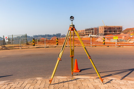 Construction building site landscape with land surveying tripod and measurement scope tool on roadsideのeditorial素材