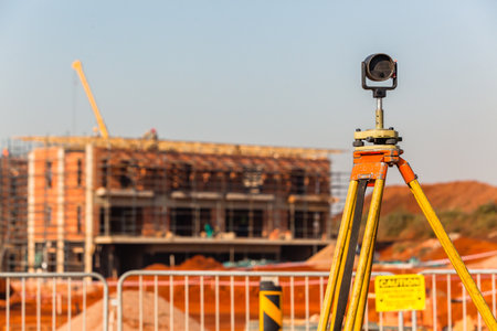 Construction building site landscape with land surveying tripod and measurement scope tool on roadsideのeditorial素材