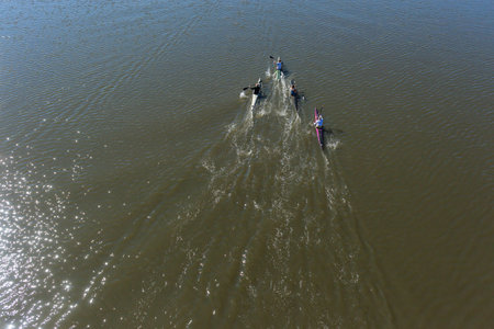Athlete paddlers canoeing training practice up glassy river waters under bridge landscape