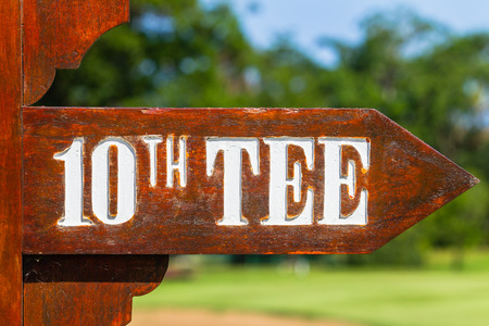 Golf course sign directions to 10th tee box front of last hole green and  trees on scenic coastal course.の写真素材