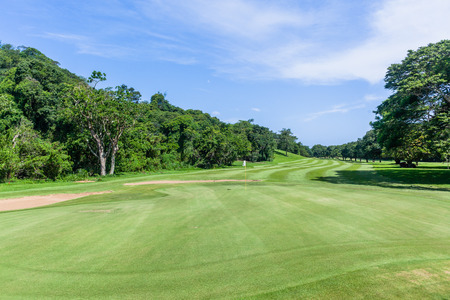 Golf course green flag hole fairway trees scenic nature reserve coastal courseの写真素材