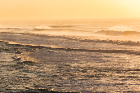 Beach ocean waves offshore winds spray morning overlooking golden color landscapeの写真素材