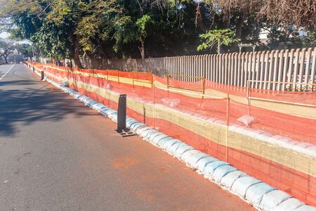 Road construction earthworks deep trench with protection blinds and sandbags for new electricty power cables installation infrastructure in resident areas.の写真素材
