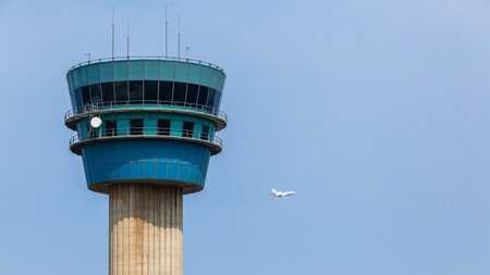 Airport control tower with jet plane flight departs into blue sky to its travel destination.のeditorial素材