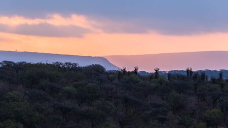 Sun setting over the african wildlife wilderness terrain landscape.の写真素材