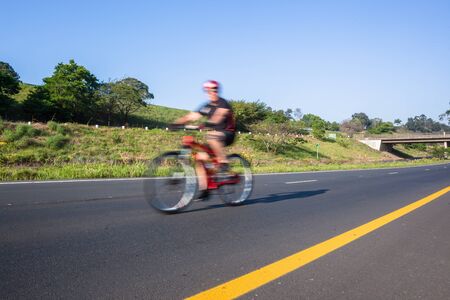 Cyclist riding on the road closeup motion speed blur cycling public race.