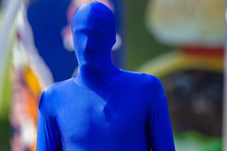 Blue man head to feet covered in full  body suite material outdoors event closeup photo.の写真素材