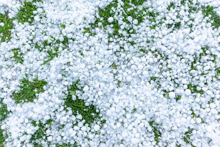 Summer thunderstorm pouring rain hail size of golf balls outdoors covering ice stones closeup detail...