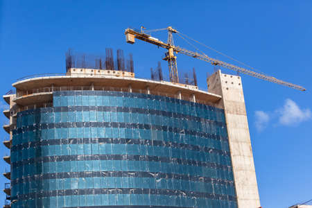 New building construction halfway about eight floors steel scaffolding and cranes with outer window...