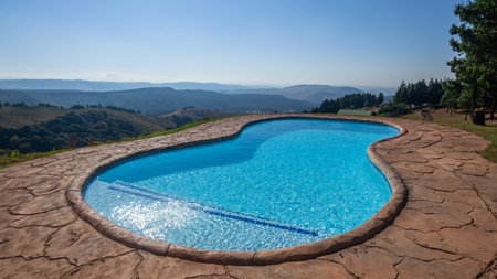 Swimming pool mid size family facility  up in the mountains  overlooking distant valley hills and trees a scenic landscape.のeditorial素材