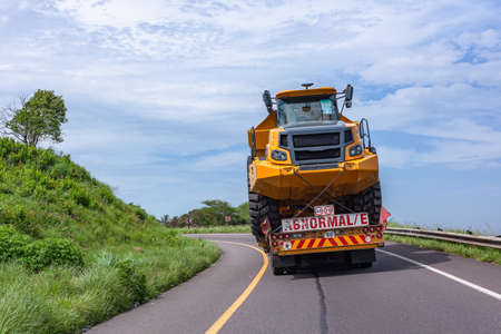 New mining heavy large tipper truck construction earthworks vehicle on abnormal/e  transport trailer traveling delivery route.の写真素材