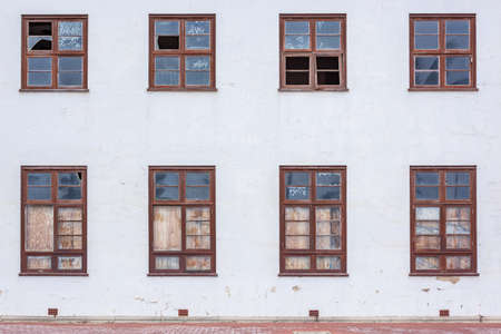 Building decaying wood framed windows with broken glass closeup section of wall structure abstract...