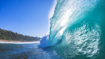 Ocean wave hollow crashing sea water onto shallow reef with backlight sun close-up swimming photo of natures power.の写真素材