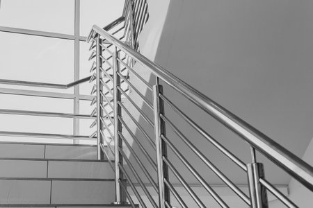 Building steps with stainless steel hand rail for public safety close-up decor  interior design.
